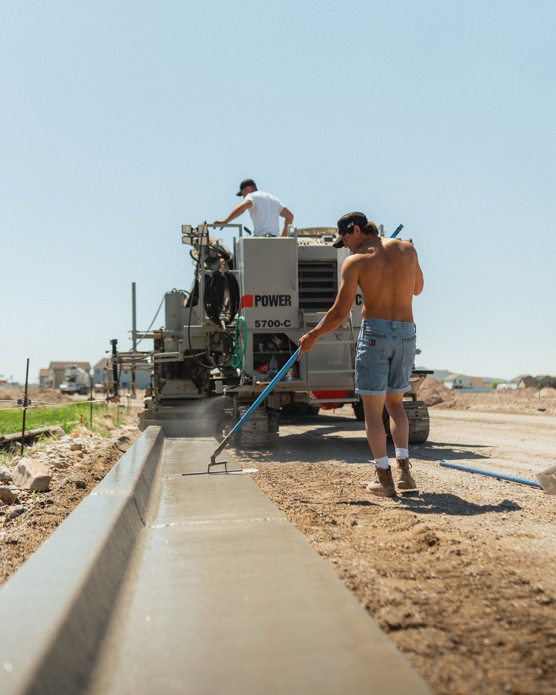 Crew member finishing a fresh run of curb and gutter