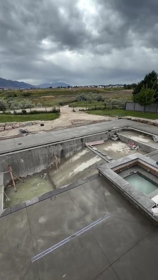 Fresh concrete deck poured around a backyard pool